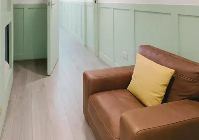 a brown couch with a yellow pillow in a living room at Pitchside Place Walk to Anfield sleeps 19 in Liverpool