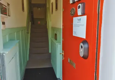 a hallway with a red door and a staircase at Pitchside Place Walk to Anfield sleeps 19 in Liverpool