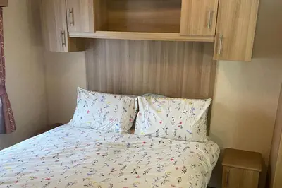 a bedroom with a bed with pillows and a cabinet at 2 Bed Caravan-Sleeps 6-Pet Friendly in Carnforth