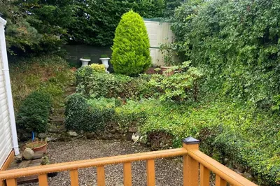 a garden with a wooden fence and bushes at 2 Bed Caravan-Sleeps 6-Pet Friendly in Carnforth