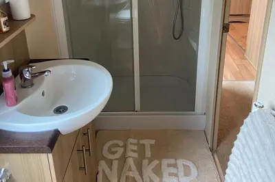 a small bathroom with a sink and a shower at 2 Bed Caravan-Sleeps 6-Pet Friendly in Carnforth