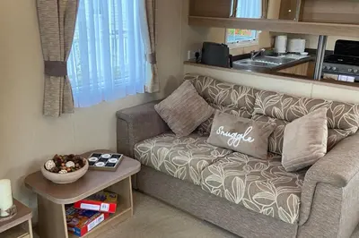 a living room with a couch and a table at 2 Bed Caravan-Sleeps 6-Pet Friendly in Carnforth