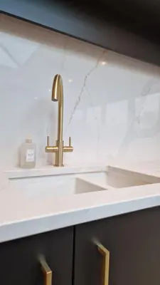 a kitchen sink with a gold faucet on a counter at Birkdale Open - modern 3 bedroom family home in Ainsdale