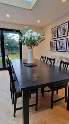 a dining room table with a vase with flowers on it at Birkdale Open - modern 3 bedroom family home in Ainsdale