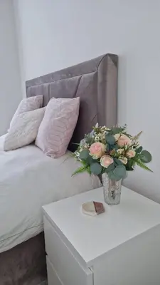 a vase of flowers on a table next to a couch at Birkdale Open - modern 3 bedroom family home in Ainsdale