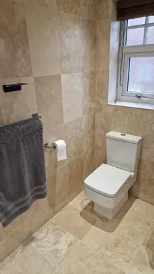 a bathroom with a toilet and a window at Birkdale Open - modern 3 bedroom family home in Ainsdale