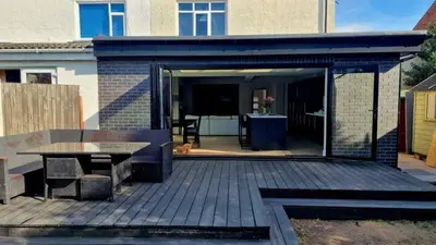 a pavilion with a table and a bench on a deck at Birkdale Open - modern 3 bedroom family home in Ainsdale