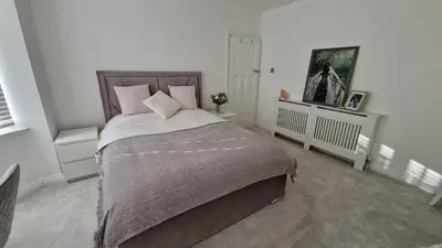 a bedroom with a bed with a blanket and pillows at Birkdale Open - modern 3 bedroom family home in Ainsdale