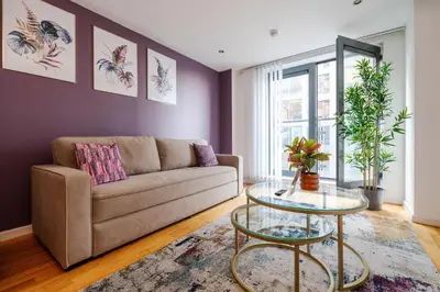 a living room with a couch and a table at Spacious City Stay 2BR 2BA Parking Included in Liverpool