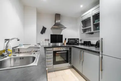 a kitchen with stainless steel appliances and a sink at Spacious City Stay 2BR 2BA Parking Included in Liverpool
