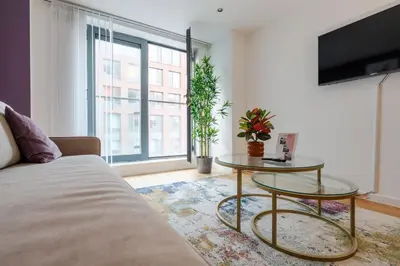 a living room with a couch and a table at Spacious City Stay 2BR 2BA Parking Included in Liverpool