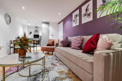 a living room with a couch and a table at Spacious City Stay 2BR 2BA Parking Included in Liverpool
