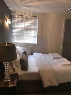 a bedroom with a bed with a lamp and a window at 2 Bedroom City Centre Georgian Quarter Apartment in Liverpool