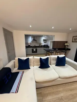 a living room with a white couch with blue pillows at 2 Bedroom City Centre Georgian Quarter Apartment in Liverpool