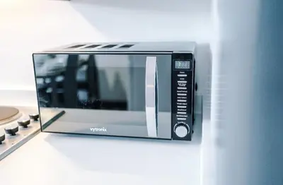a microwave oven sitting on top of a counter at Three Bedroom House in Wigan - Perfect for family! in Ince-in-Makerfield