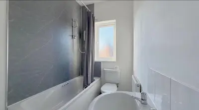 a bathroom with a toilet and a tub and a sink at Three Bedroom House in Wigan - Perfect for family! in Ince-in-Makerfield