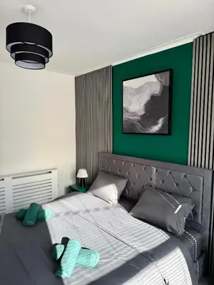 a bedroom with a bed with a green wall at D&D Emerald House Anfield in Liverpool