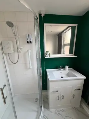 a bathroom with a shower and a sink and a mirror at D&D Emerald House Anfield in Liverpool