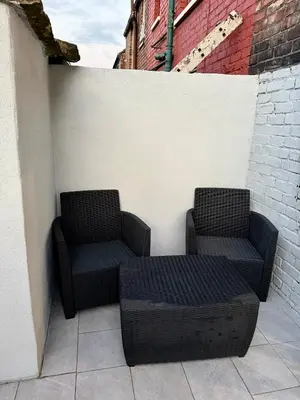 two wicker chairs and a table on a patio at D&D Emerald House Anfield in Liverpool