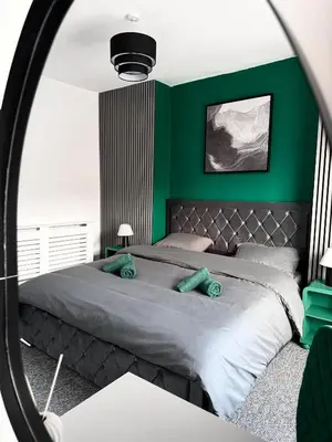 a bedroom with green walls and a bed with a mirror at D&D Emerald House Anfield in Liverpool
