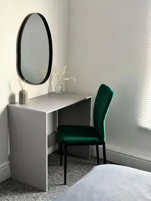 a desk with a mirror and a green chair at D&D Emerald House Anfield in Liverpool