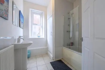 a white bathroom with a sink and a shower at The Lytham Retreat - New! Spacious & Luxurious in Lytham St Annes