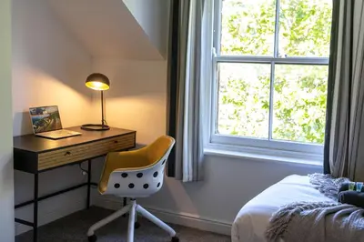 a bedroom with a desk and a chair and a window at The Lytham Retreat - New! Spacious & Luxurious in Lytham St Annes