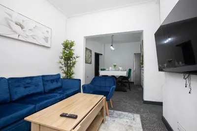 a living room with a blue couch and a table at Premium Luxury Home by Anfield & City Centre in Liverpool