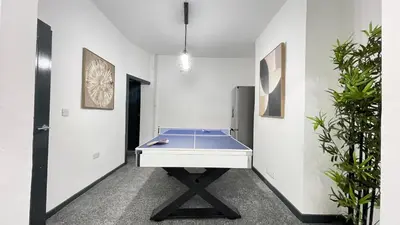 a ping pong table in a room with plants at Premium Luxury Home by Anfield & City Centre in Liverpool