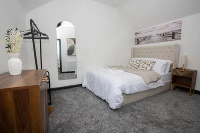 a bedroom with a bed and a dresser and a mirror at Premium Luxury Home by Anfield & City Centre in Liverpool