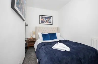 a bedroom with a blue and white bed with white shoes on it at Premium Luxury Home by Anfield & City Centre in Liverpool