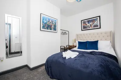 a bedroom with a large bed with a blue comforter at Premium Luxury Home by Anfield & City Centre in Liverpool
