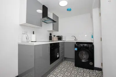 a kitchen with a washer and a washing machine at Premium Luxury Home by Anfield & City Centre in Liverpool