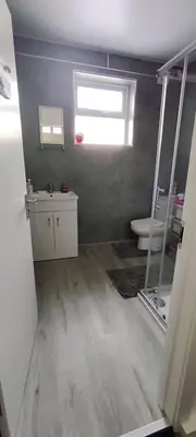 a bathroom with a toilet and a sink and a window at Quality Rooms in Liverpool