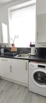 a kitchen with a sink and a washing machine at Quality Rooms in Liverpool