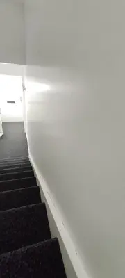 a staircase in a building with white walls and black stairs at Quality Rooms in Liverpool