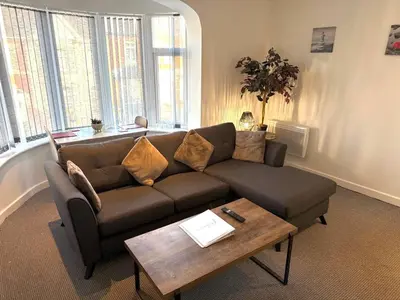 a living room with a couch and a coffee table at 1 Double Bedroom Great Location - Holmfield Road in Blackpool