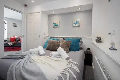 a bedroom with a large bed with blue pillows at 1 Double Bedroom Great Location - Holmfield Road in Blackpool