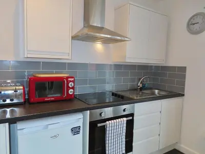 a kitchen with a red microwave and a sink at 1 Double Bedroom Great Location - Holmfield Road in Blackpool