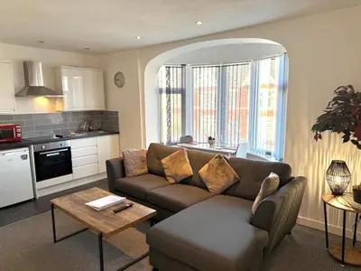 a living room with a couch and a table at 1 Double Bedroom Great Location - Holmfield Road in Blackpool