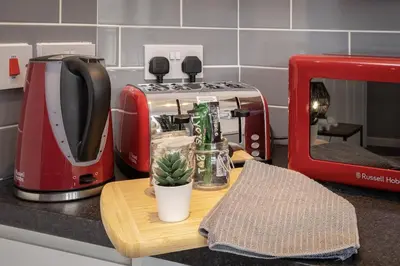 a red toaster sitting on a kitchen counter with a cactus at 1 Double Bedroom Great Location - Holmfield Road in Blackpool