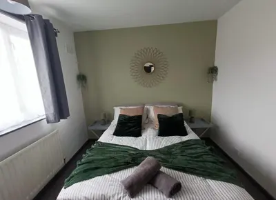 a bedroom with a bed with two pillows and a mirror at #72 Stylish 3 bedroom sleeps 7 Wigan House in Pemberton