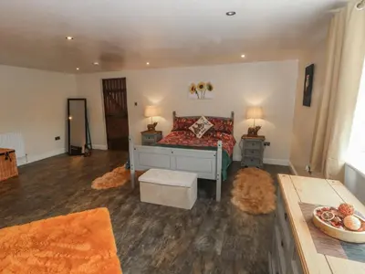 a bedroom with a bed and two tables and two lamps at Pompian Lodge in Leyland