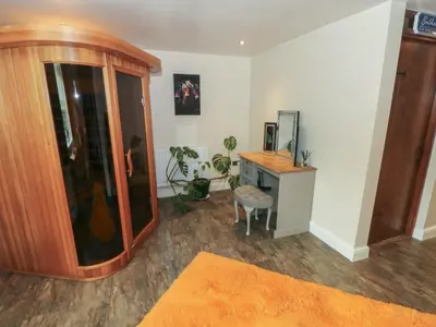 a room with a desk and a cabinet with a mirror at Pompian Lodge in Leyland