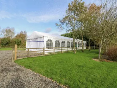 a white tent in a field with a fence at Pompian Lodge in Leyland