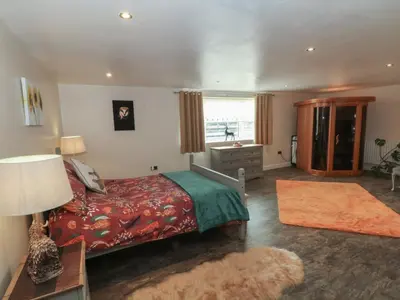 a bedroom with a bed and a desk and a window at Pompian Lodge in Leyland