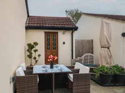 a small patio with a table and chairs at Pompian Lodge in Leyland