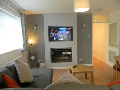a living room with a couch and a tv on a wall at Blackpool San Remo Bungalows 9 & 10 in Blackpool