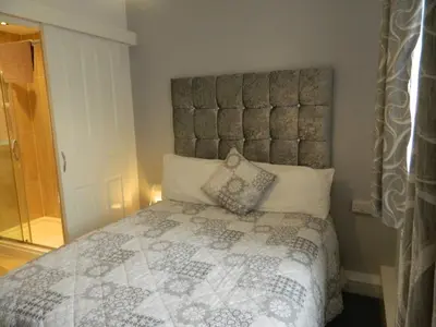 a bedroom with a large bed with a large headboard at Blackpool San Remo Bungalows 9 & 10 in Blackpool