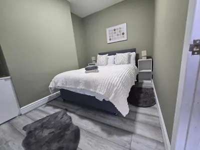 a bedroom with a bed with a white comforter at House 5 Minutes from Sefton Park in Liverpool